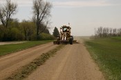 County Blade on gravel road.